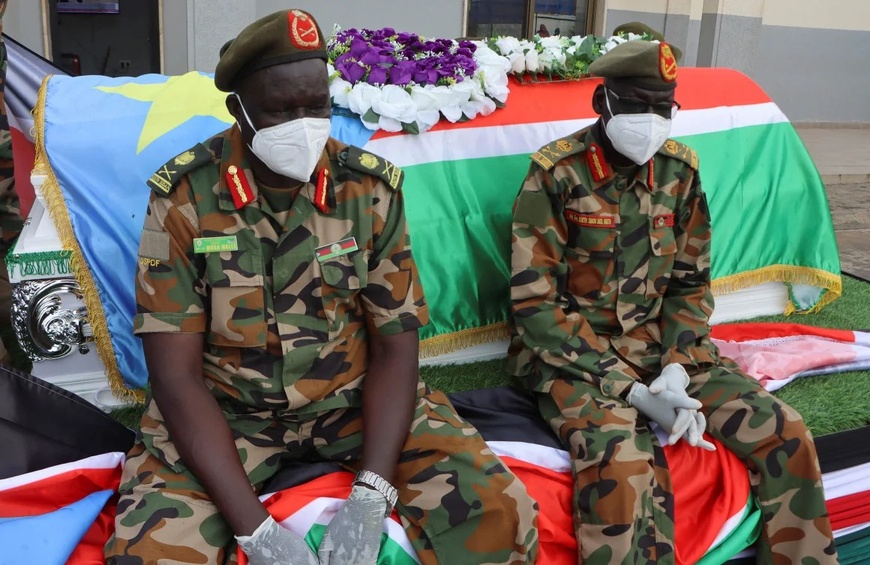 Les forces de sécurité du Soudan du Sud sont assises près du cercueil du général David Majur Dak, commandant des Forces de défense du peuple du Soudan du Sud, tué lors d'une attaque de l'Armée blanche. Photo : Samir Bol/Reuters