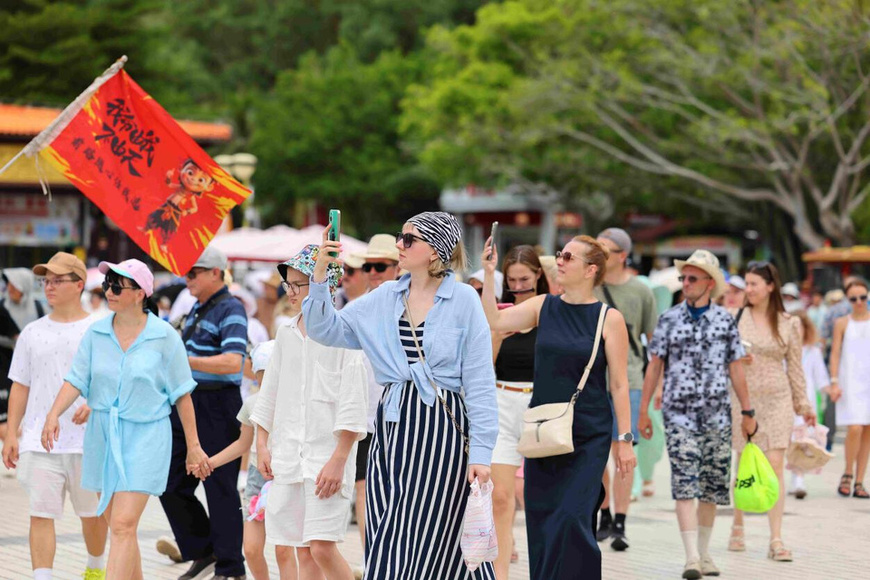 Foreign tourists visit the Nanshan Cultural Tourism Area in Sanya, south China's Hainan province, July 23, 2025. (Photo/Chen Wenwu)