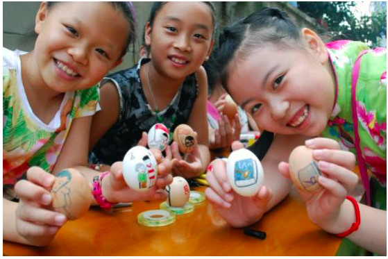 Des élèves de l’école primaire de la communauté de Jinshan, située rue Heping dans le district de Runzhou de la ville de Zhenjiang, dans la Province du Jiangsu, montrent des dessins représentant les valeurs socialistes qu’ils ont peintes sur des coquilles d’œufs, montrant toute l’importance qu’ils accordent à ces valeurs fondamentales. (Photo : Le Quotidien du Peuple en ligne)