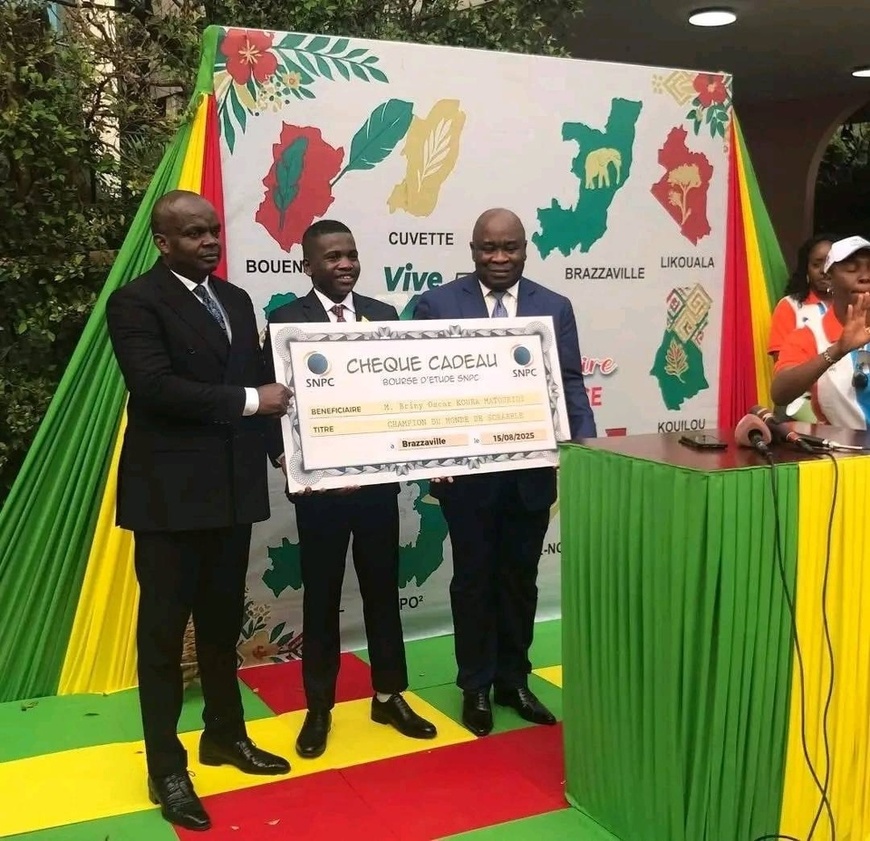 Briny Oscar Matouridi et le chèque offert par la SNPC