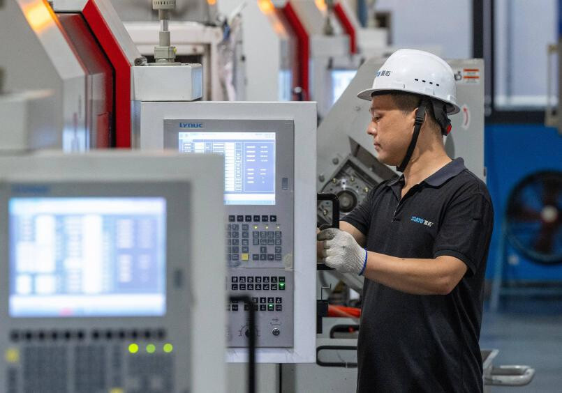 A technician inspects automated fastener production equipment at a workshop in Zhenhai district, Ningbo, east China's Zhejiang province. (Photo/Hu Xuejun)