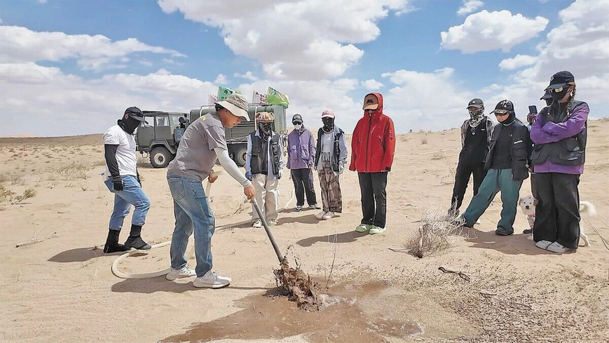 Zhong Lin (second from left) instructs volunteers on seedling management. (People's Daily/Zhao Shuaijie)
