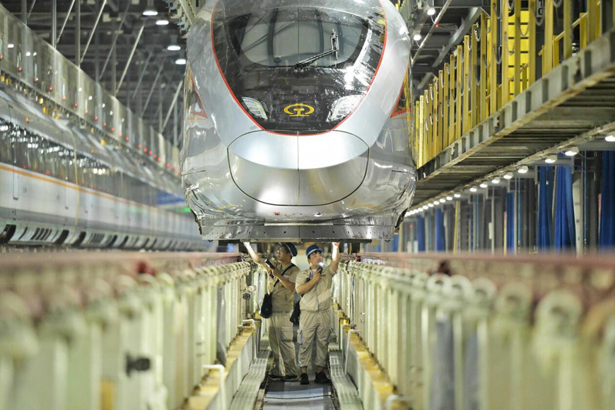 Technicians inspect a bullet train at a maintenance facility in Zhengzhou, central China's Henan province. (Photo/Wang Wei)