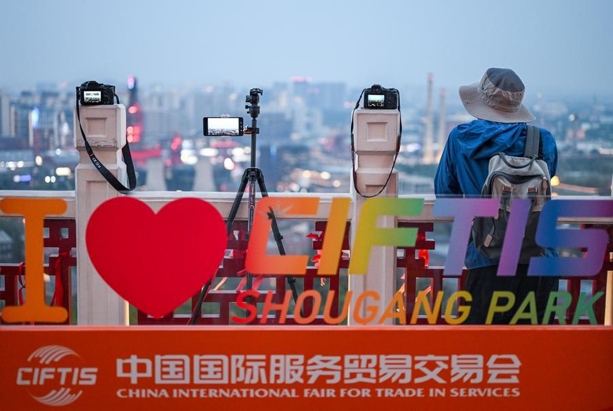 This photo taken on Sept. 11, 2025 shows a photography enthusiast taking pictures of the night view of Shougang Park in Beijing, capital of China.  (Xinhua/Chen Yehua)