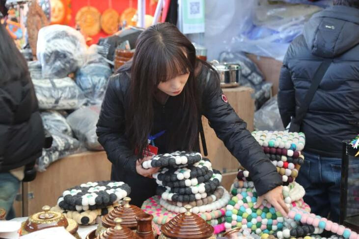 A woman buys Nepali teacup pads at the Yarlung Commodity Fair in Shannan, southwest China's Xizang autonomous region. (Photo by Yongchen Drolkar)