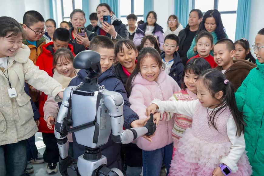 A robot shakes hands with children in Wusu, northwest China's Xinjiang Uygur autonomous region. (Photo/Li Renxi)