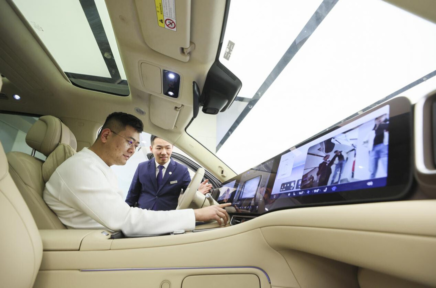 A man experiences a new energy vehicle in a shopping mall in Tengzhou, east China's Shandong province. (Photo/Zhao Qirui)