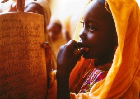 Une jeune fille avec son coran dans les bras à l'école. © mabellephoto.com