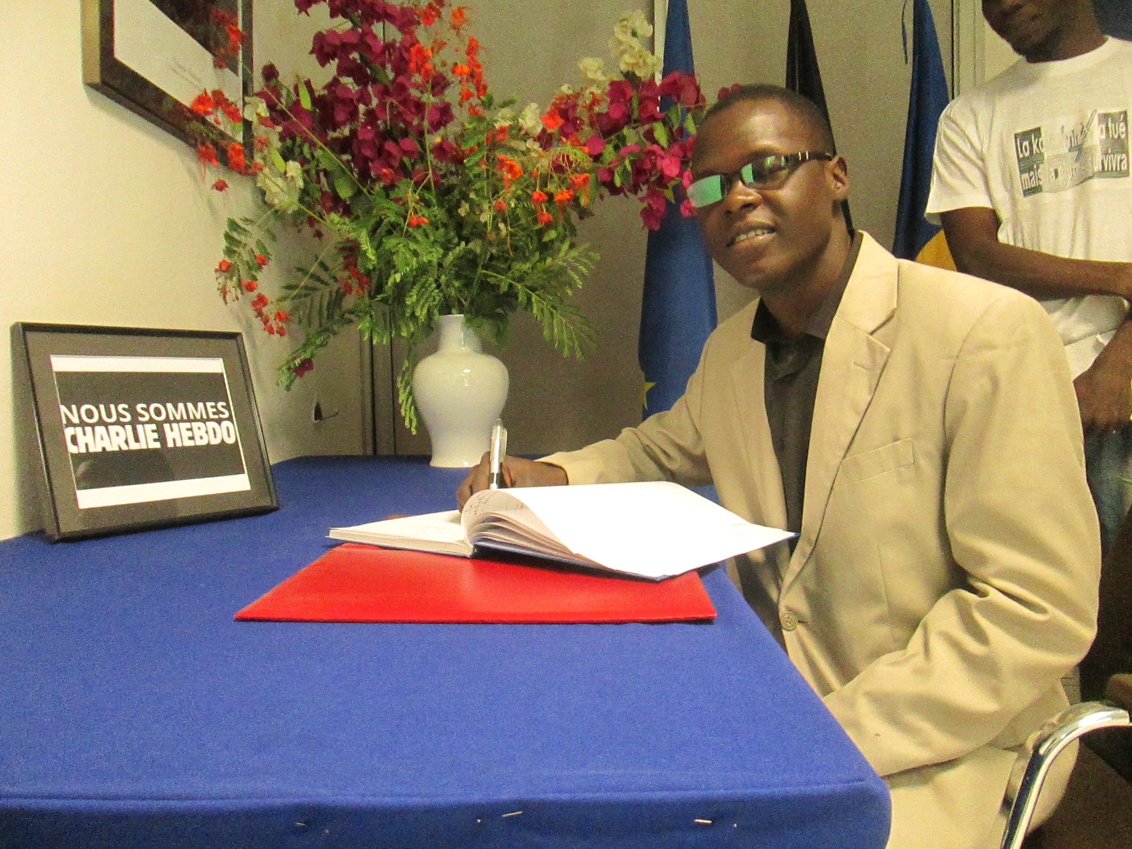 Le directeur général d'Alwihda Actualités, Mahamat Ramadane, signant le livre des condoléances à l'Ambassade de France au Tchad.