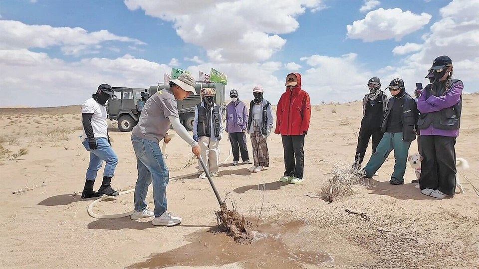 Zhong Lin (second from left) instructs volunteers on seedling management. (People's Daily/Zhao Shuaijie)