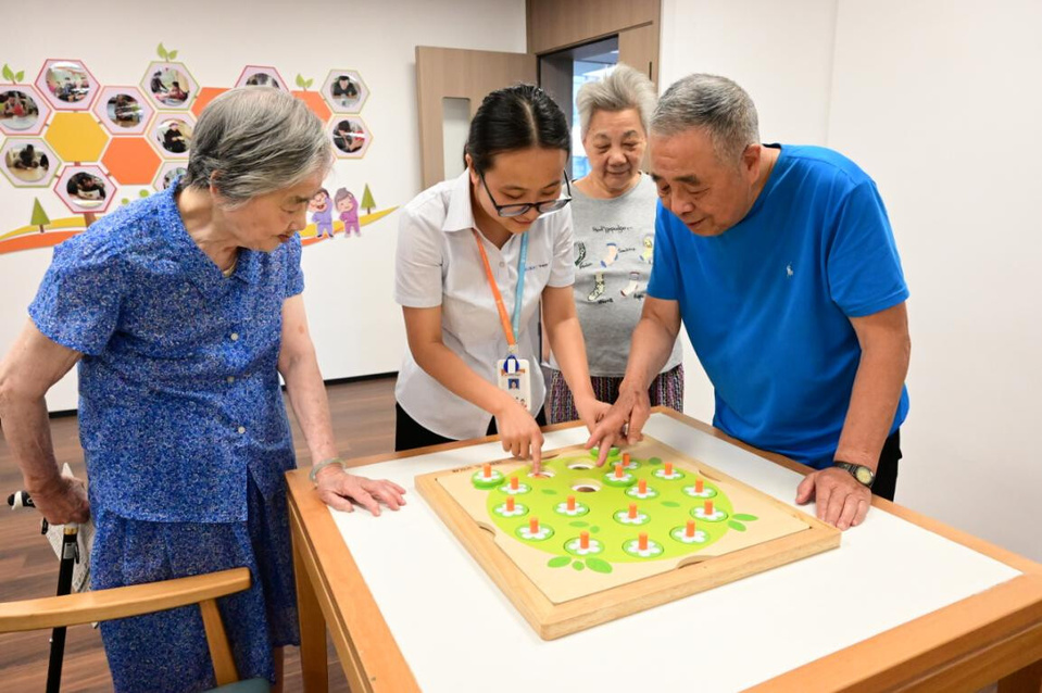 Seniors engage with a toy designed to enhance mental agility under the guidance of a social worker at a social welfare center in Taijiang district, Fuzhou, southeast China's Fujian province, July 8, 2025. (Photo/Zhang Wenliang)