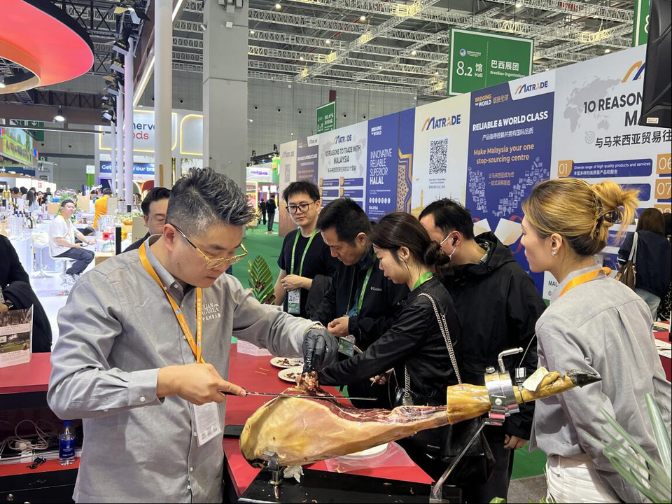 Visitors taste Spain's Iberian ham at the 8th China International Import Expo, Nov. 5, 2025. (People's Daily/Jiang Bo)