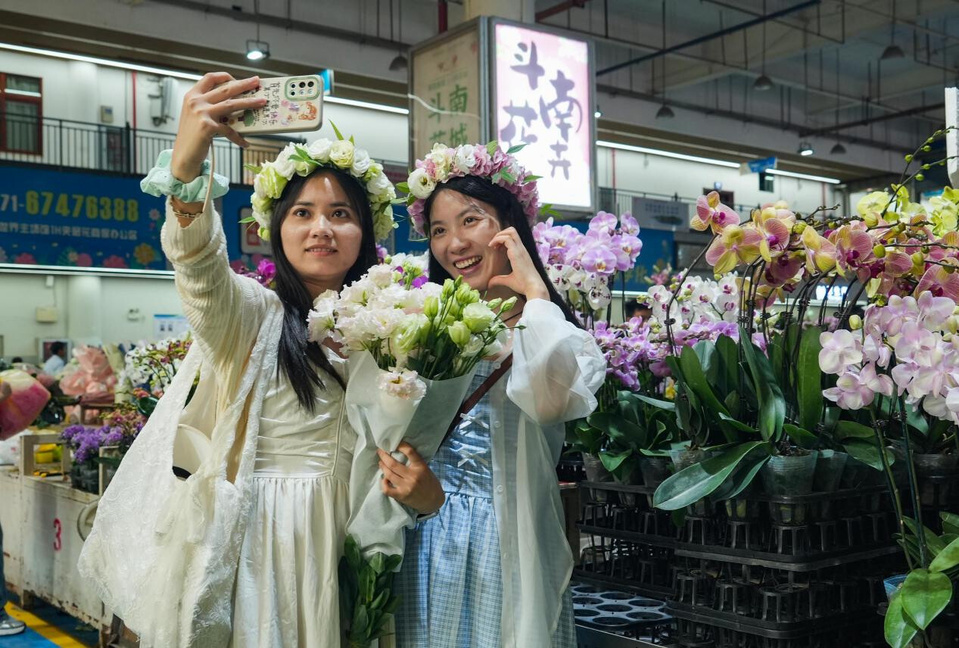 Tourists pose for a picture at the Dounan Flower Market in Kunming, southwest China's Yunnan province. (Photo/Zheng Yi)