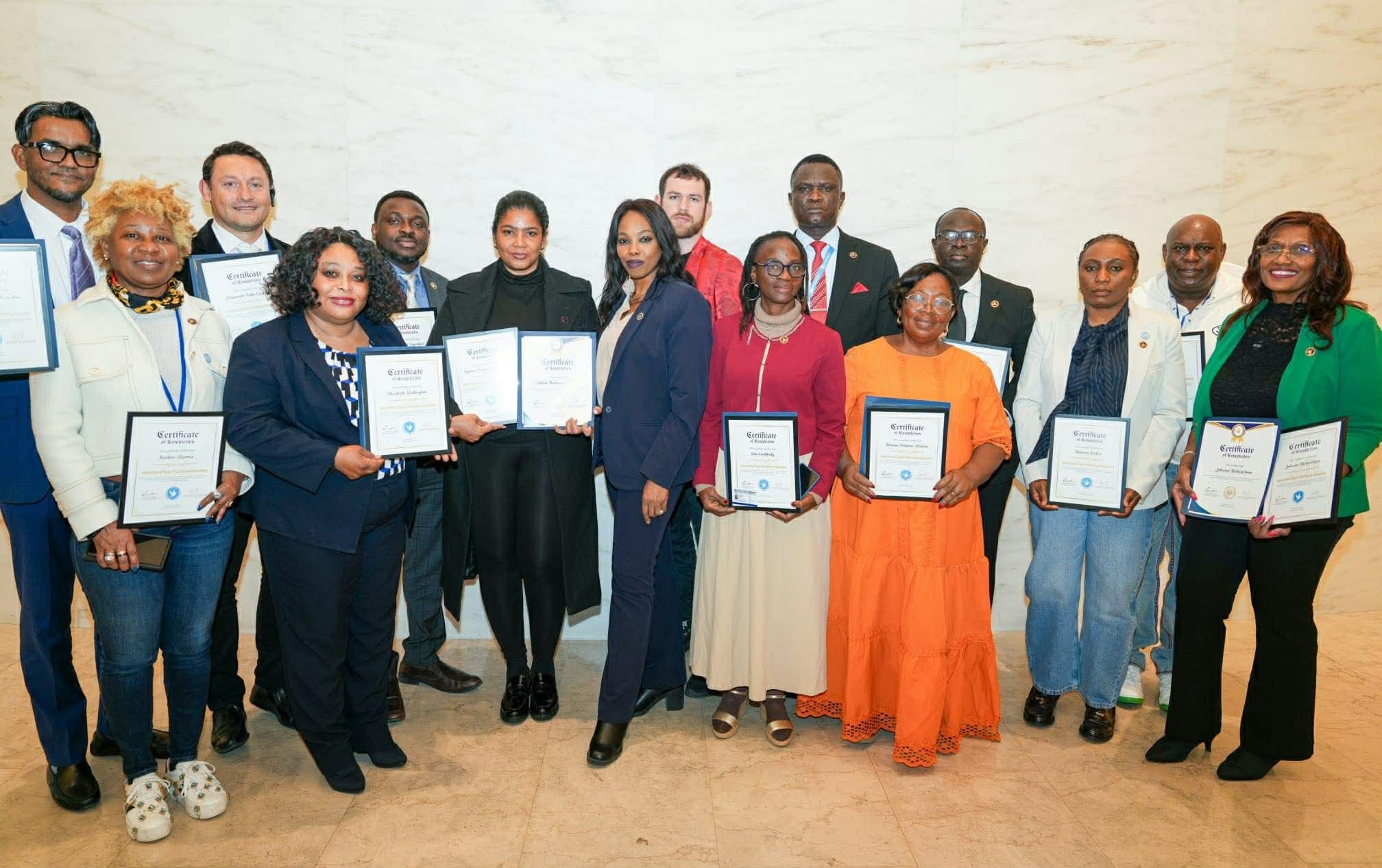 Les participants à la master-class posent avec le Dr Andrise Bass (au centre), fondateur et directeur exécutif de l'IPPDR, tenant leurs certificats au siège des Nations Unies à New York. Photo : IPPDR