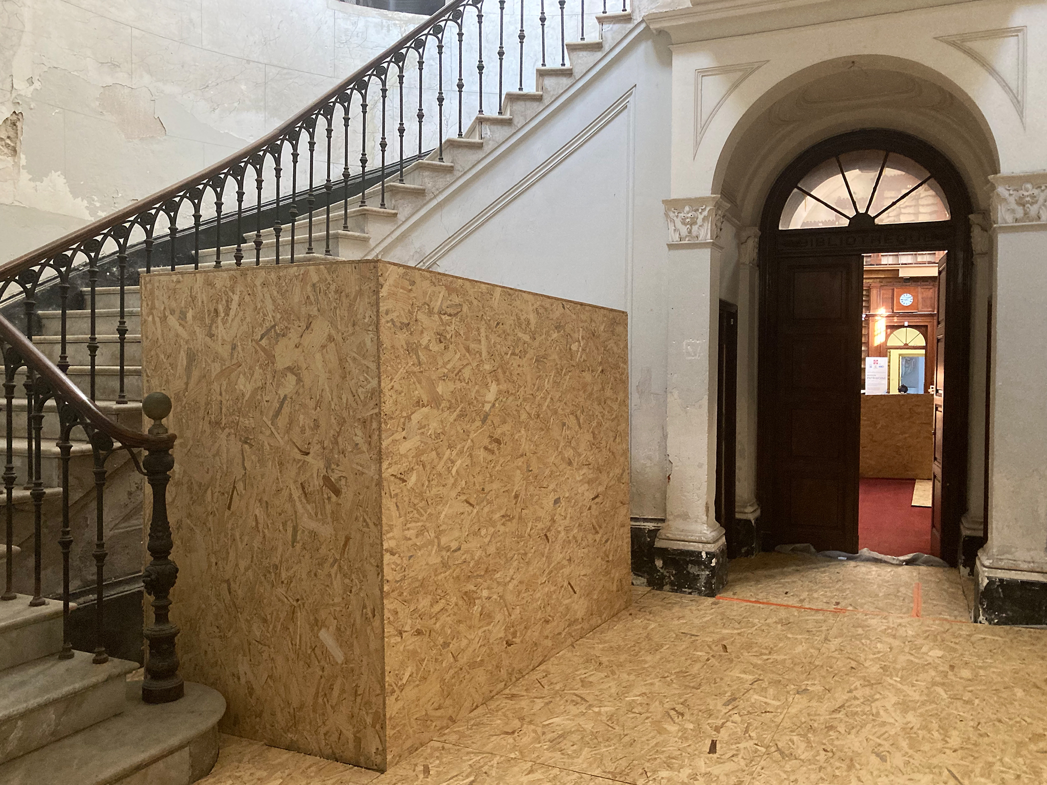 Les lions du hall d'entrée, mis temporairement en sécurité sous des panneaux de bois.