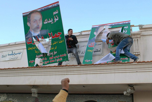 Des manifestants égyptiens déchirant des affiches de Gamal Moubarak, le fils du président égyptien Hosni Moubarak, Alexandrie le 25 janvier 2011 — AFP/Getty Images