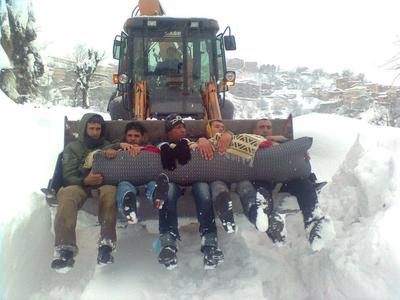 Transport se faisant dans des tracto-pelles pour cause de fermetures des routes par la neige (PH/ Lyes Chebli)