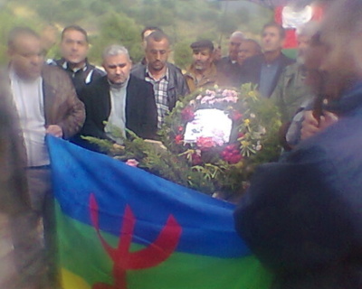 Dépot de gerbe de fleurs sur la tombe du militant Muhend U Harun. Au centre de la photo troublée par la pluie, Bouaziz Ait-Chebib, président du MAK (PH/DR)