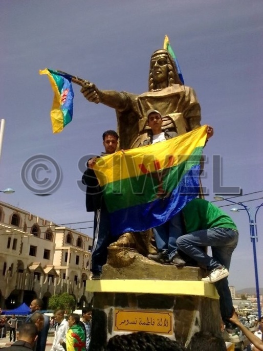 Les kabyles se réapproprient leurs héros. Ici, le 20 avril 2011, les militants du MAK ornent de drapeaux amazighs la stèle de l'héroïne kabyle Fadhma n Soummer à Tuvirett (BOUIRA), dont le nom, sur la plaque, est écrit exclusivement en arabe.
