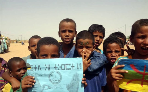 Enfants touaregs exhibant  petites affiches en Tifinagh et drapeau Amazigh (berbère). (PH/DR)