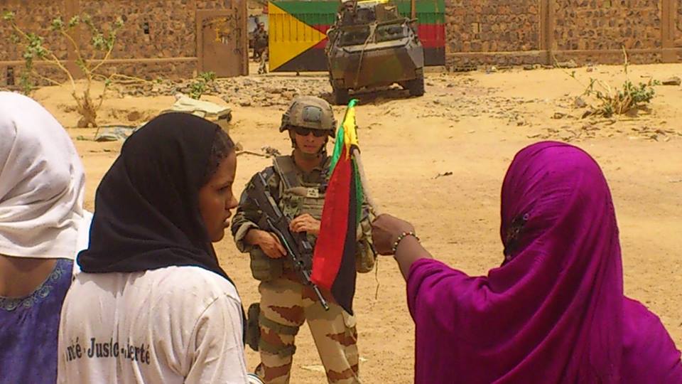 Drapeau de l'Azawad en main, des jeunes femmes de l'Azawad face à un soldat de Serval à Kidal le 15 septembre 2013 (PH/DR)