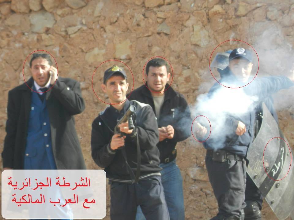 La police avec les agresseurs arabes tirent sur les maisons des mozabites. la police avec des armes, les arabes avec des pierres. le titre de la photo en arabe est : la police algérienne avec les arabes malékites (PH/DR)