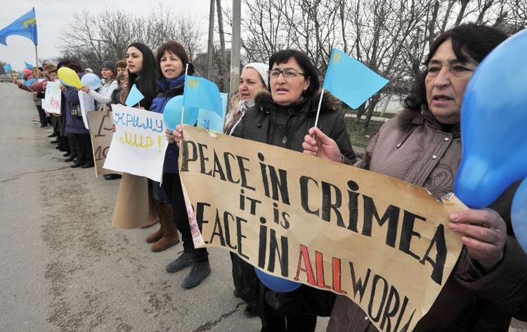 Des femmes brandissent des drapeaux tatars réclamant la paix en Crimée à Simferopol le 8 mars 2014 (PH/DR)