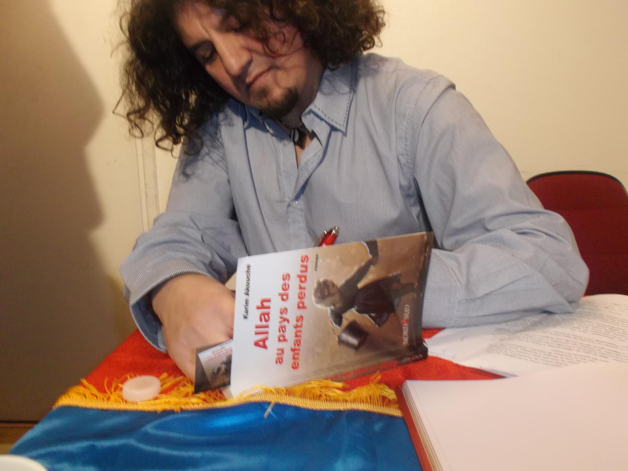 Karim Akouche dédicaçant son livre "Allah au pays des enfants perdus" (PH/DR)