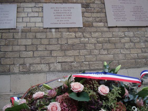 La gerbe de fleurs déposés au pied des noms des morts pour la France