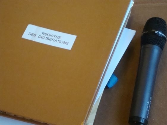 Le registre des délibérations du conseil du Ier arrondissement et le micro servant au directeur général des services pour faire l'appel des élus.